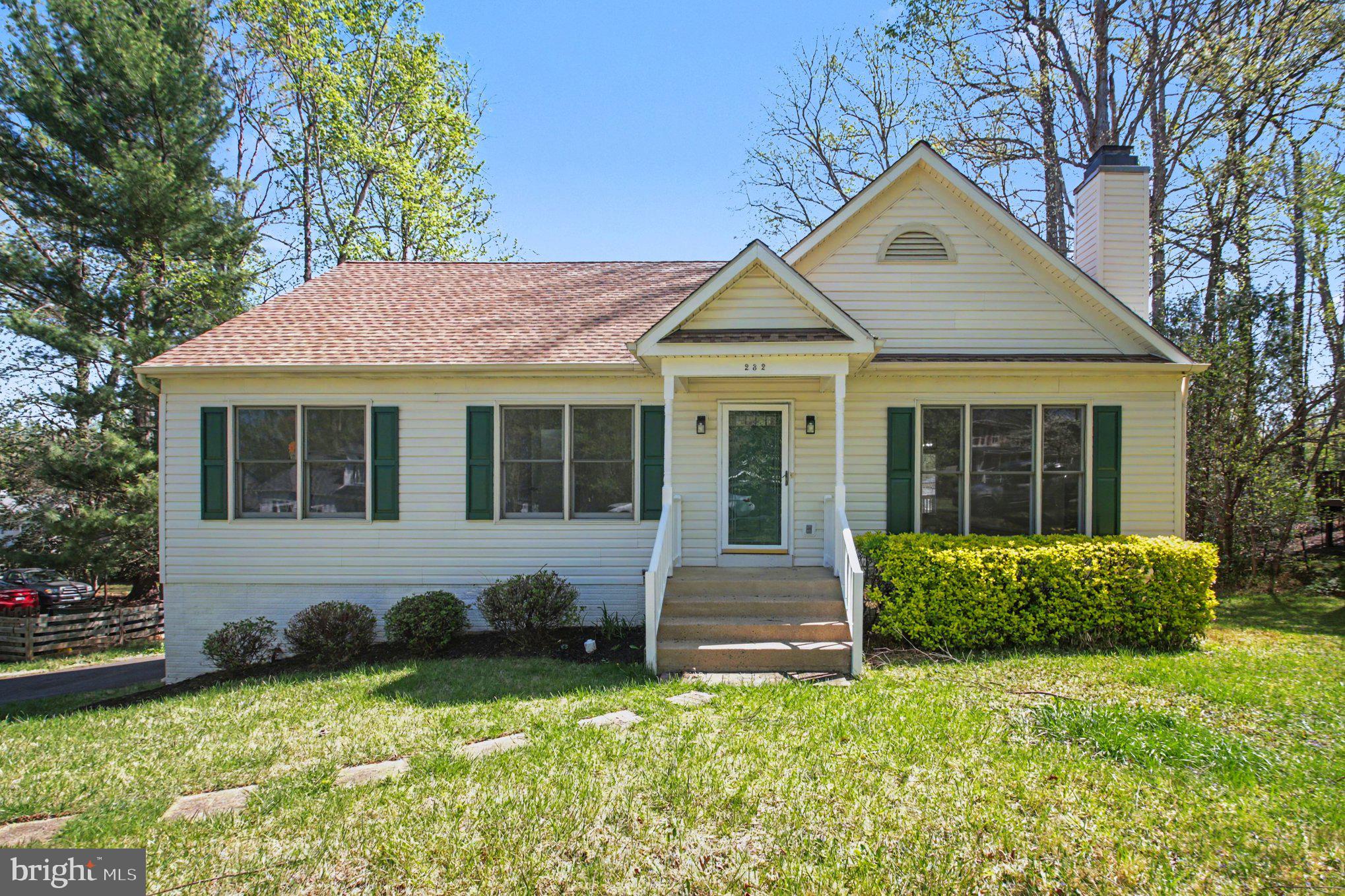 a front view of a house with yard and green space