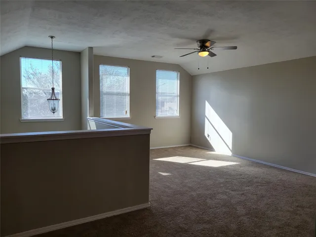 a view of a livingroom with a ceiling fan and kitchen view