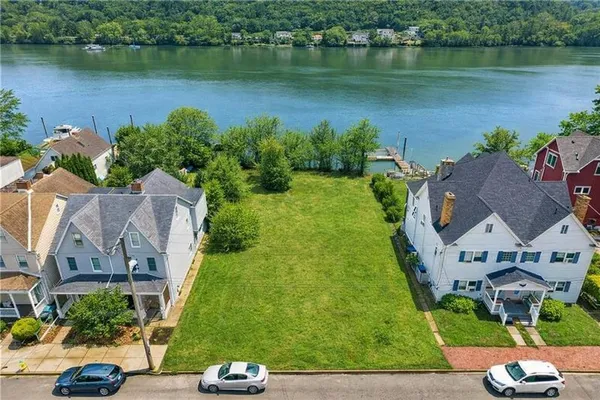 an aerial view of a house with garden space and lake view