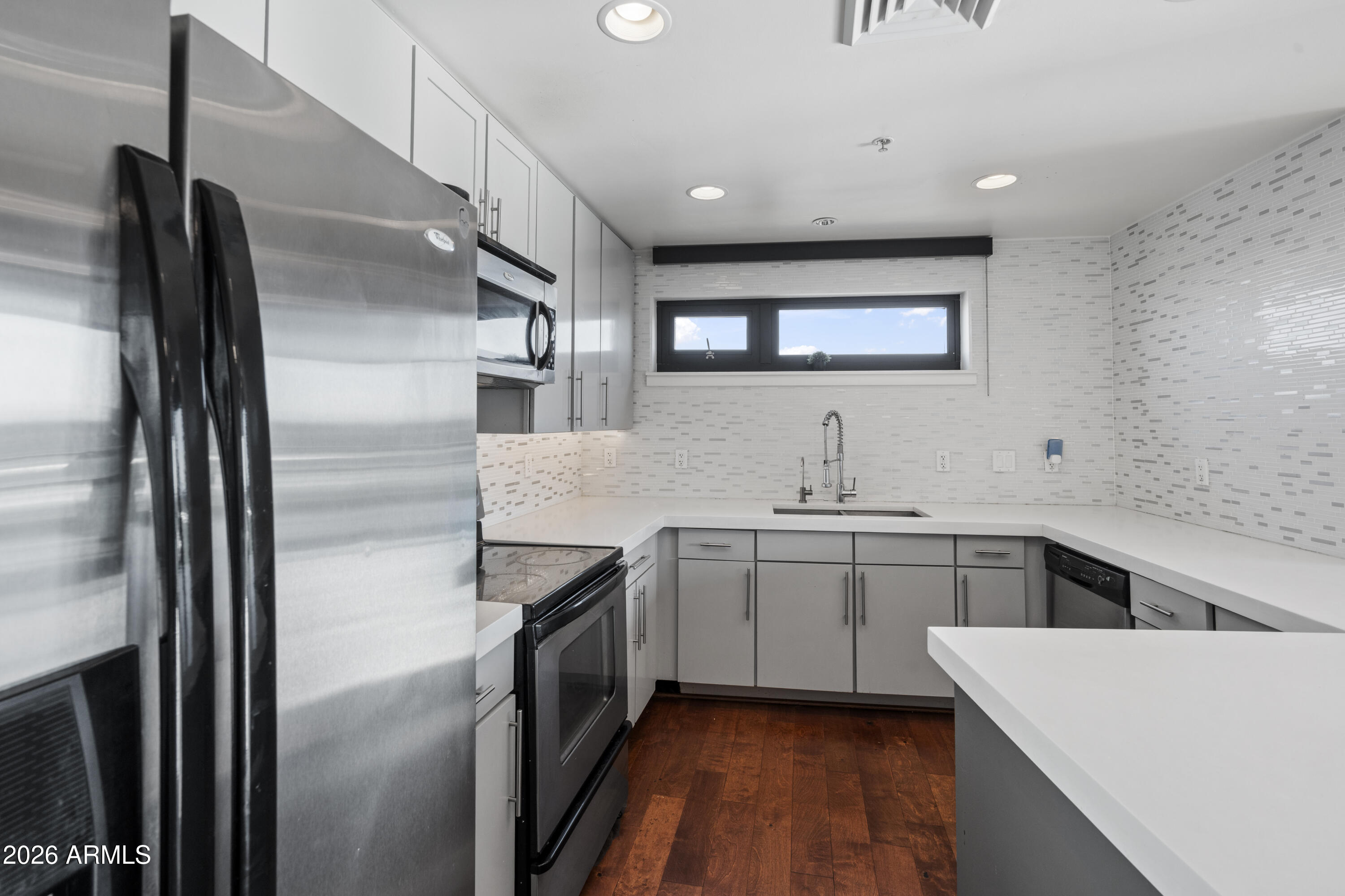 310 South 4th Street, Unit 601 Phoenix, AZ 85004 - Photo 3 of 29 a kitchen with a sink stainless steel appliances and white cabinets