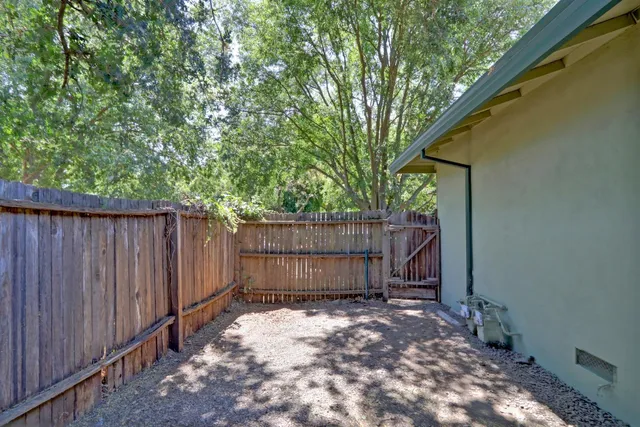a view of a backyard with potted plants and wooden fence