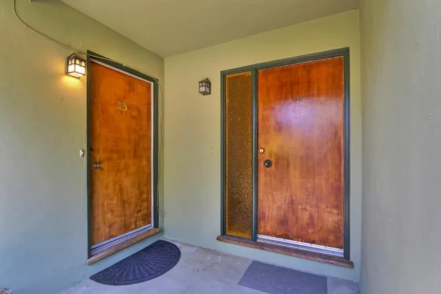 an entryway with a door and wooden floor