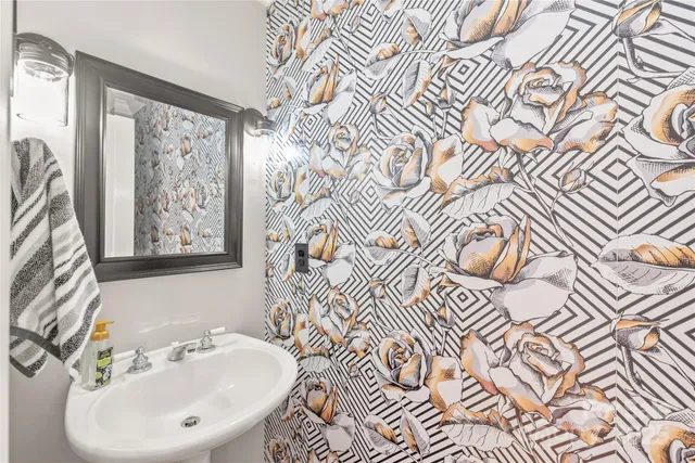 a bathroom with a sink and mirror with bathtub