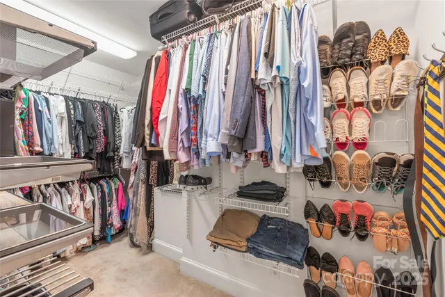 a view of walk in closet with clothes and shoes