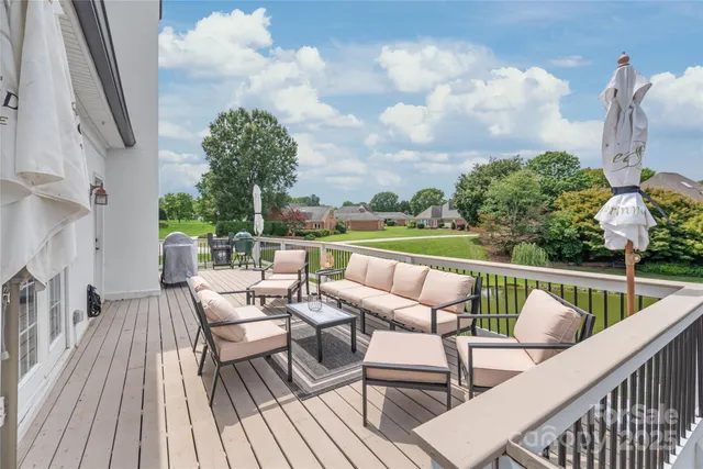 a balcony with wooden floor outdoor seating and barbeque oven