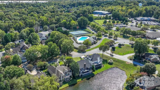 an aerial view of a house with a yard and greenery