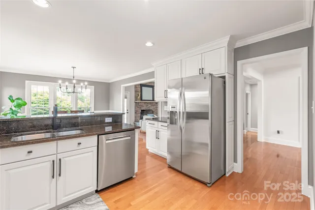 a kitchen with stainless steel appliances a refrigerator a sink a stove a microwave a counter space and cabinets