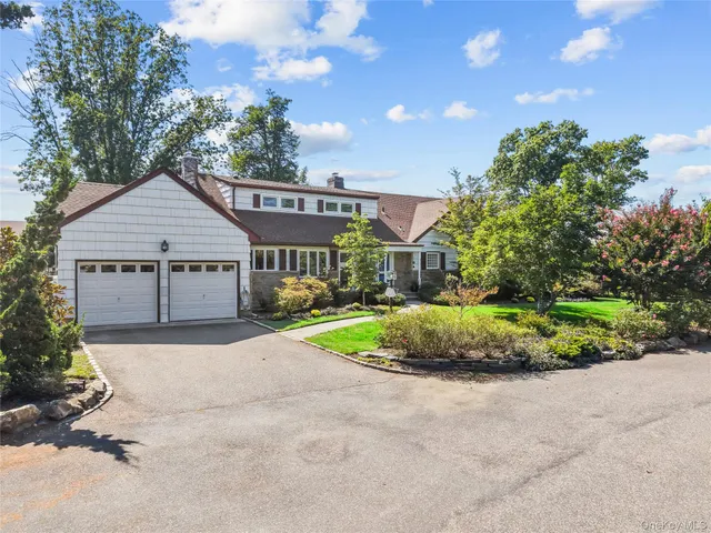 a front view of a house with a yard and potted plants