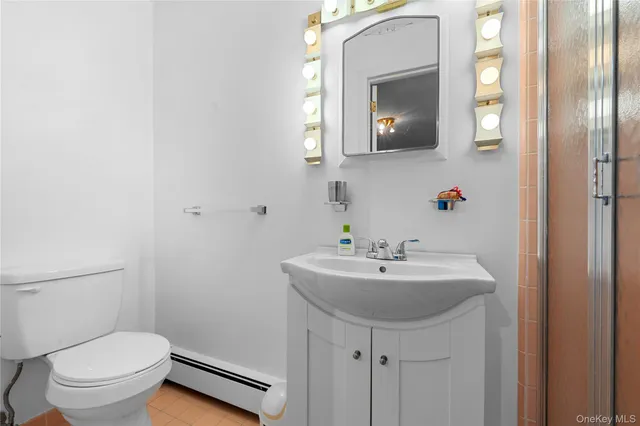 a bathroom with a toilet a sink and mirror