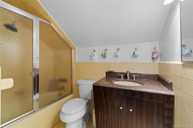 a bathroom with a granite countertop sink a toilet and shower