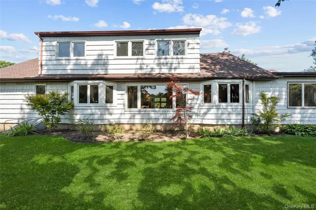 a front view of a house with a yard and potted plants