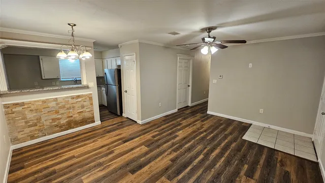 a view of a livingroom with a chandelier fan and windows