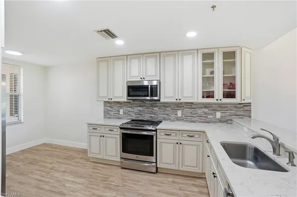 a kitchen with stainless steel appliances granite countertop a refrigerator and a stove top oven