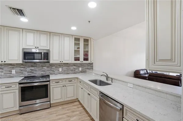 a kitchen with a sink stove top oven and cabinets