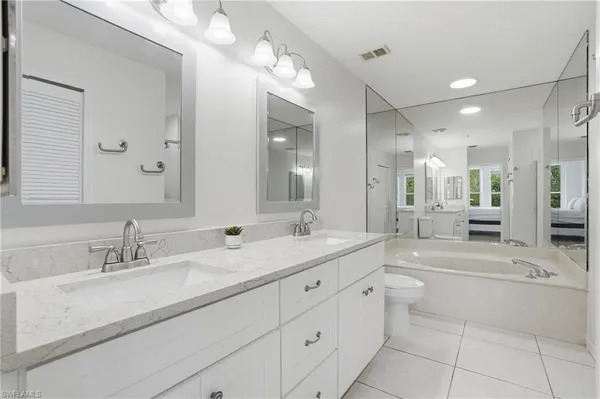 a bathroom with a sink a toilet a mirror and shower