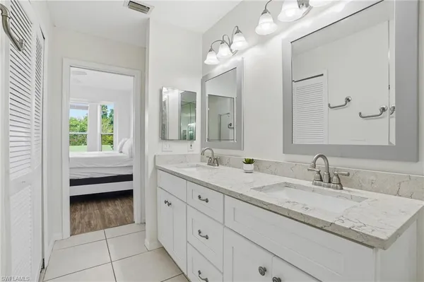 a en suite bathroom with a granite countertop sink a mirror and a