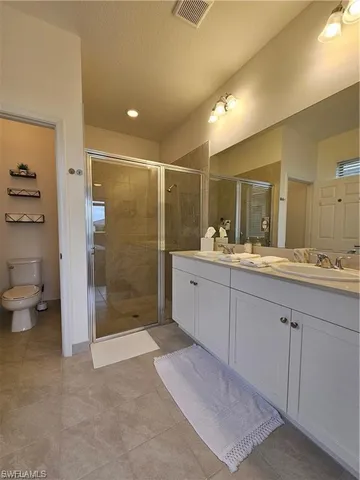 a bathroom with a double vanity sink toilet and shower
