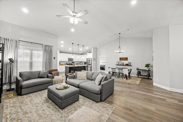 a living room with furniture kitchen view and a chandelier