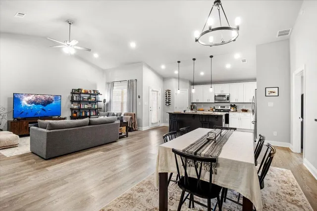 a kitchen with kitchen island stainless steel appliances a dining table and chairs