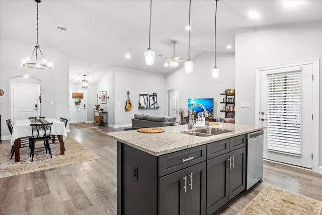 a kitchen with a sink a center island a counter space and a dining table