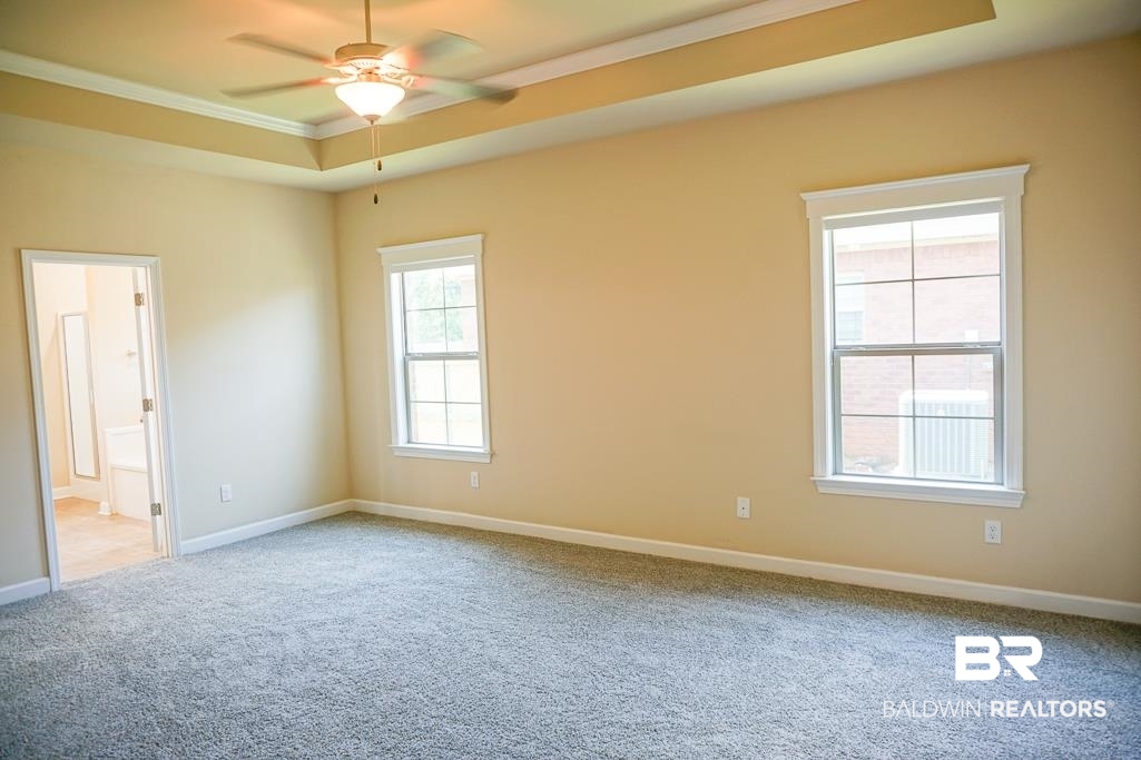 593 Begeman Road Mobile, AL 36608 - Photo 10 of 23 Spare room with a healthy amount of sunlight, carpet floors, ceiling fan, and a raised ceiling