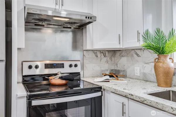 a kitchen with a stove and a white cabinets