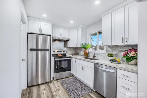 a kitchen with stainless steel appliances granite countertop a refrigerator sink and cabinets