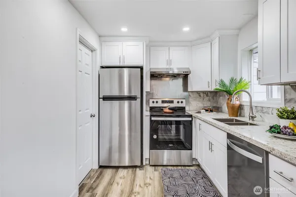 a kitchen with stainless steel appliances a refrigerator sink and stove