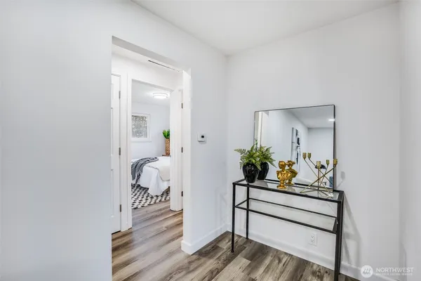 a view of a hallway with wooden floor and a potted plant