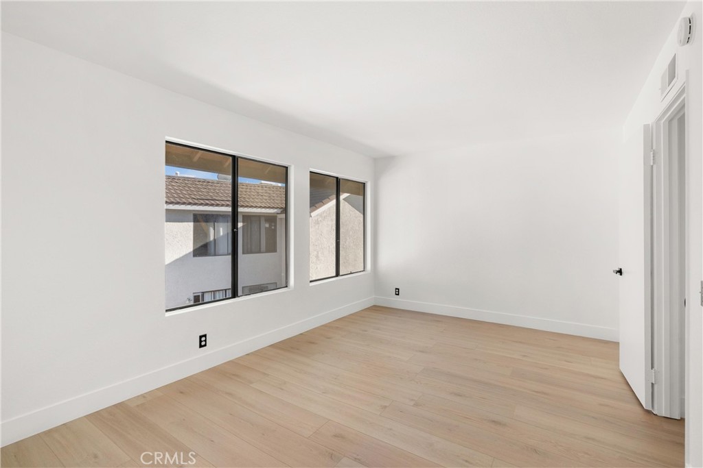25885 Trabuco Road, Unit 91 Lake Forest, CA 92630 - Photo 20 of 36 a view of an empty room with wooden floor and a window