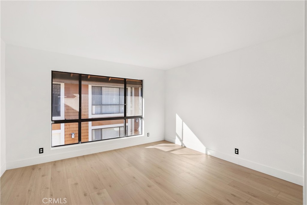 25885 Trabuco Road, Unit 91 Lake Forest, CA 92630 - Photo 23 of 36 an empty room with wooden floor and windows