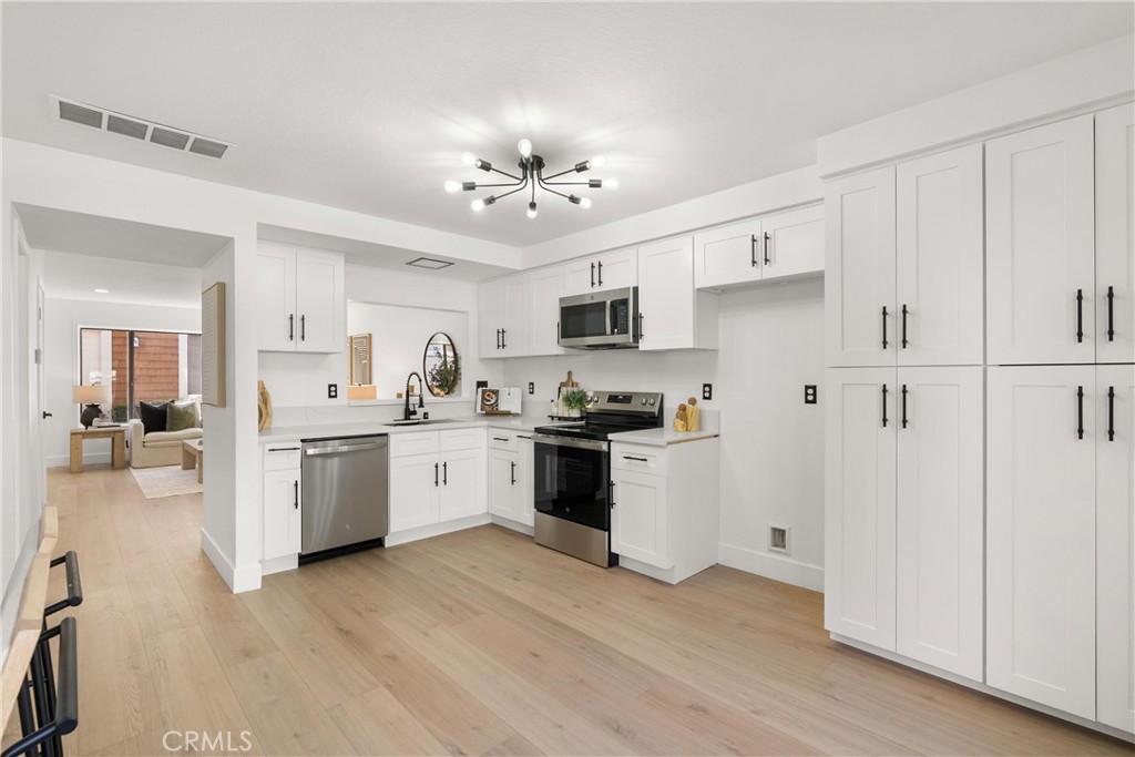 25885 Trabuco Road, Unit 91 Lake Forest, CA 92630 - Photo 10 of 36 a kitchen with granite countertop white cabinets and white appliances