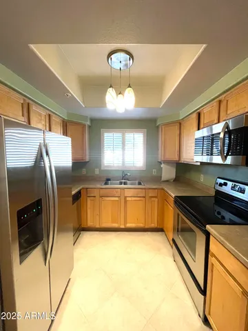 a kitchen with stainless steel appliances granite countertop a sink a stove and a refrigerator