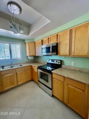 a kitchen with stainless steel appliances granite countertop a sink a stove cabinets and a refrigerator