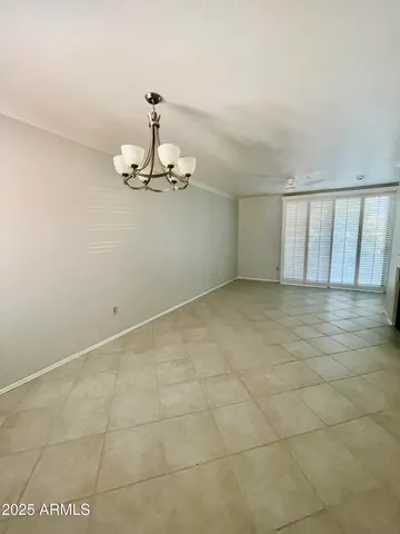 a view of a room with a chandelier fan and kitchen view