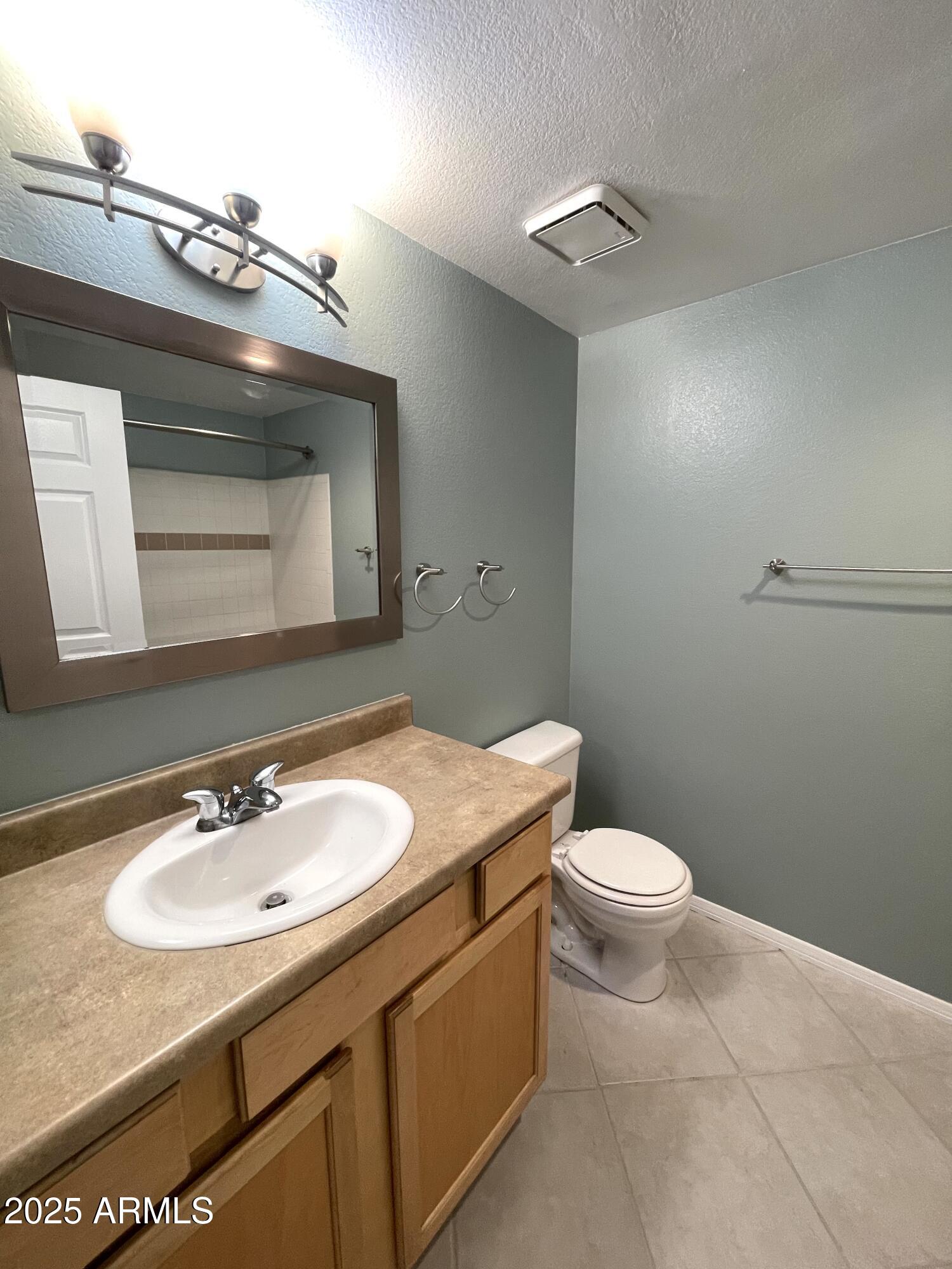 750 East Northern Avenue, Unit 1047 Phoenix, AZ 85020 - Photo 9 of 19 a bathroom with a granite countertop sink a toilet and a mirror