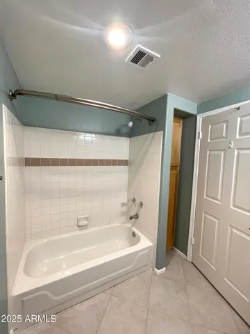 a spacious bathroom with a bathtub and shower