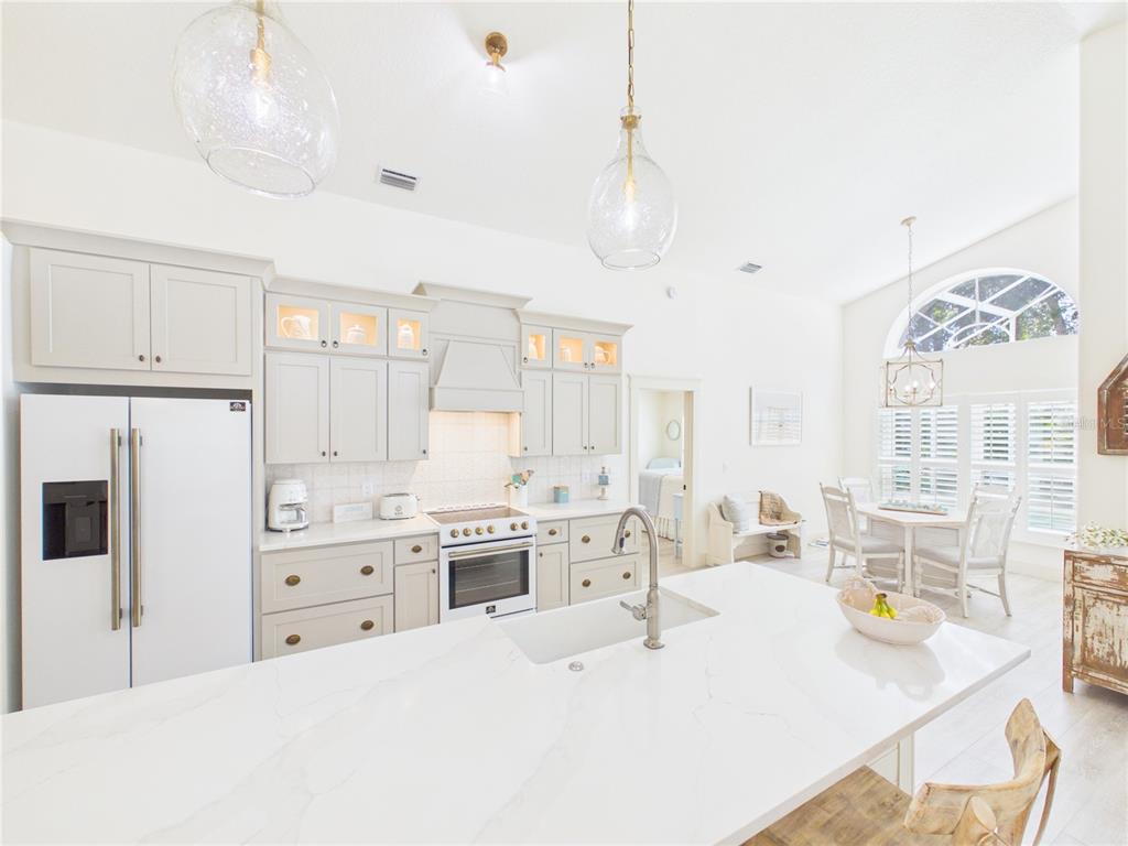 426 Long Cove Road Ormond Beach, FL 32174 - Photo 12 of 73 a kitchen with stainless steel appliances kitchen island granite countertop a sink a stove and a refrigerator