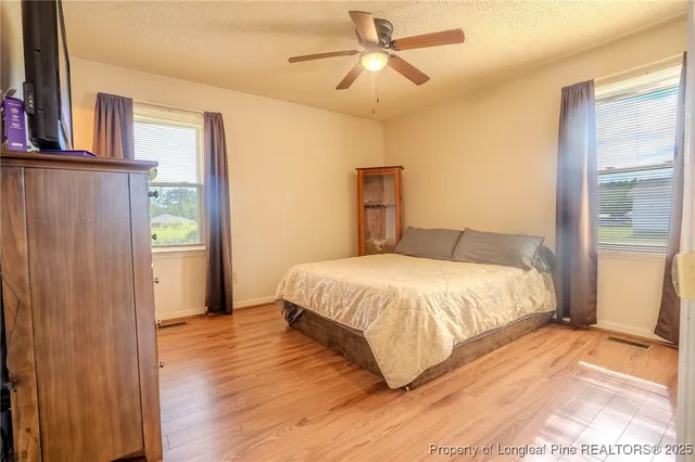 a bedroom with a bed and wooden floor