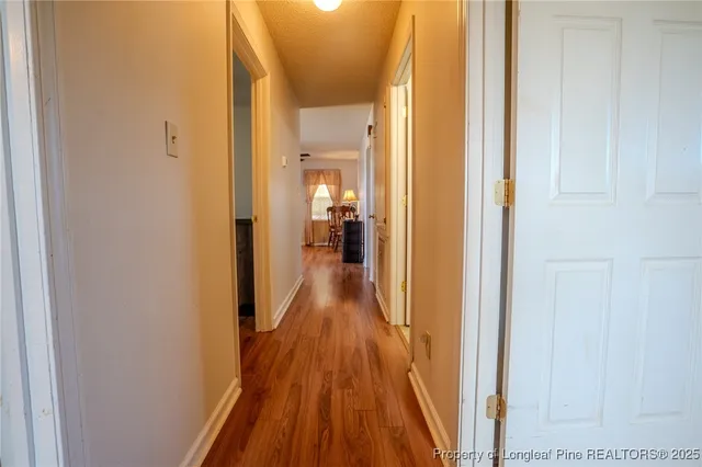 a view of a hallway with wooden floor