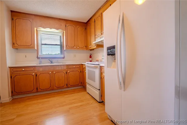 a kitchen with white cabinets and white appliances