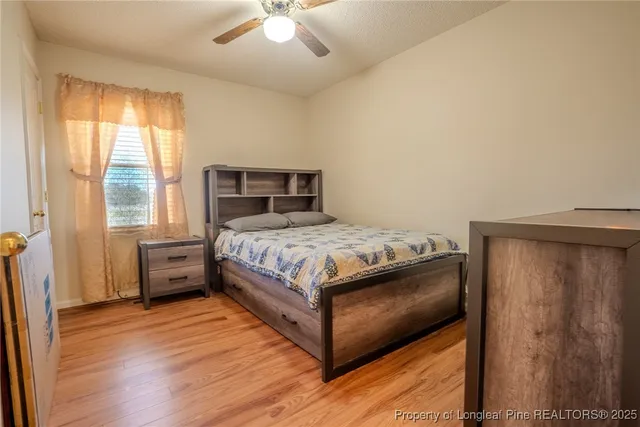 a bedroom with a bed and wooden floor