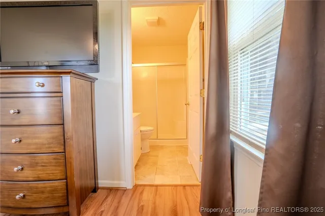 a view of a walk in closet with wooden floor
