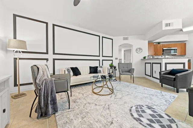 a work room with furniture a rug and a window