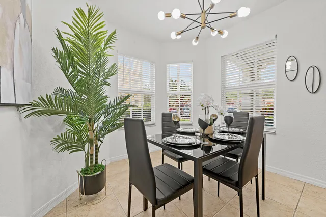 a dining room with furniture potted plants and wooden floor