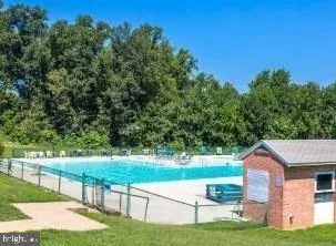 a view of backyard with swimming pool and green space