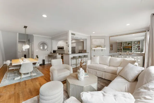 a living room with furniture white walls and kitchen view