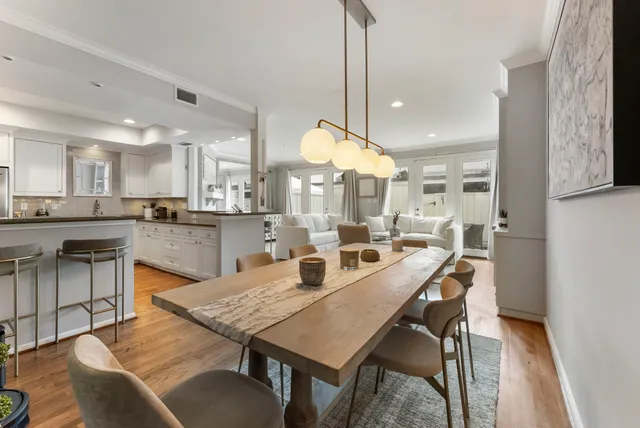 a dining room with stainless steel appliances granite countertop a stove a kitchen island a dining table and chairs