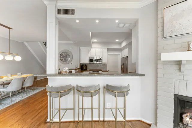 a kitchen with a dining table chairs and white cabinets