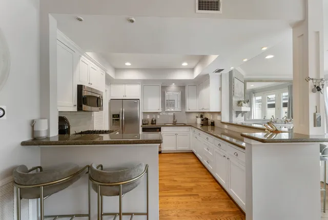 a large kitchen with granite countertop lots of counter space and stainless steel appliances